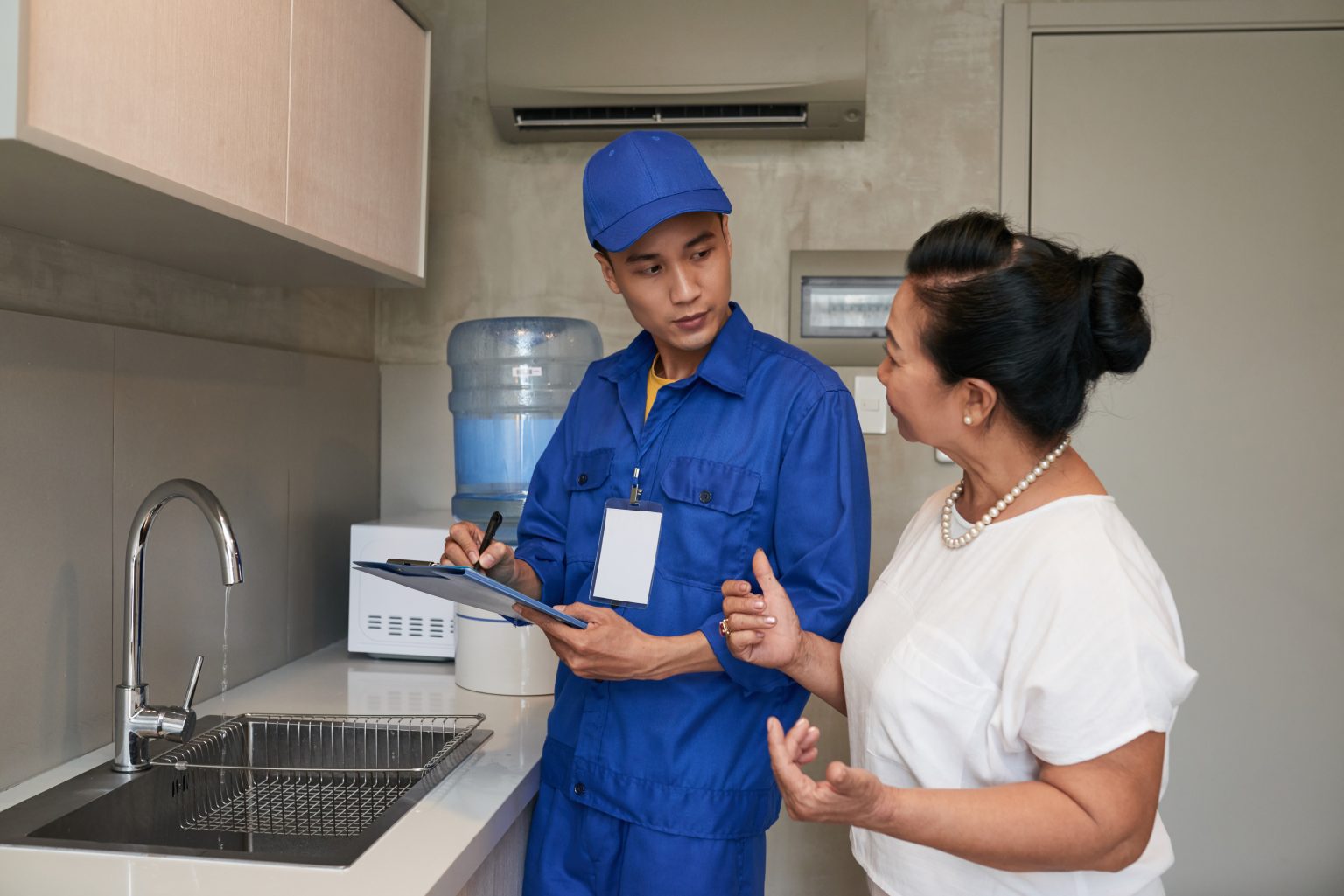 Aqua Care technician discussing an RO water filtration system with a homeowner
